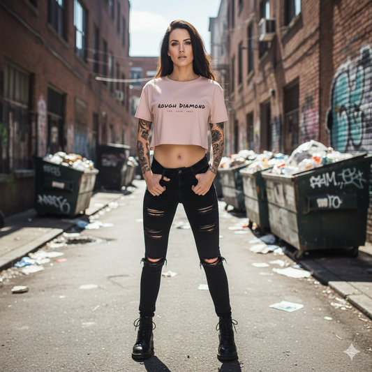 Woman wearing a pink t-shirt and black ripped jeans standing in an urban alleyway.