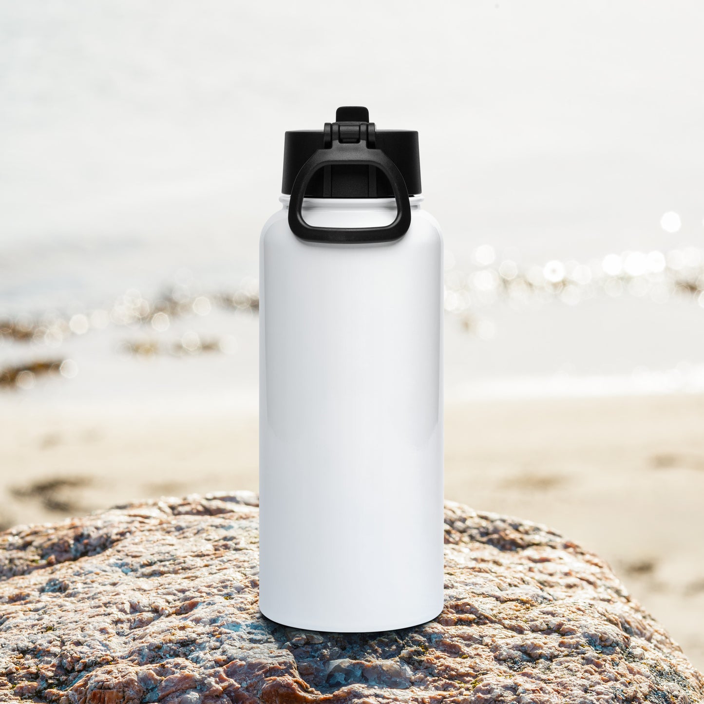 Rough Diamond white water bottle with Real red lips graphic sitting on a rock in a beach setting back view
